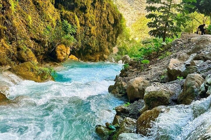 The turquoise thermal river running between the canyon rocks