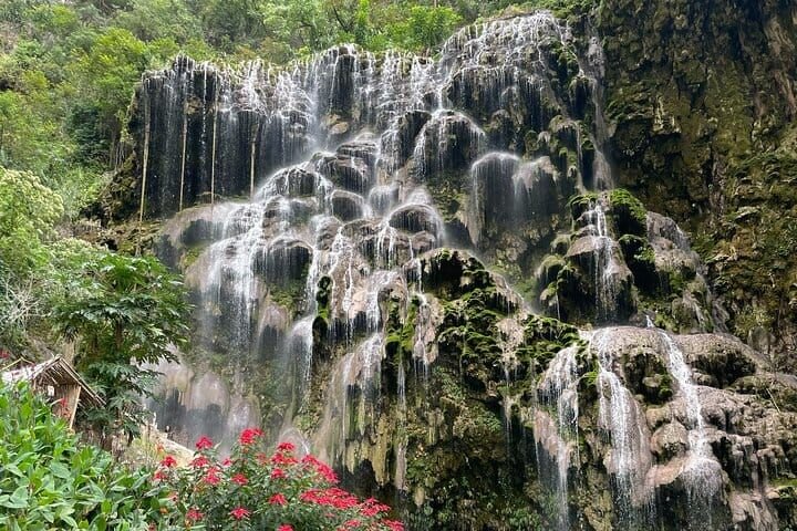 The Tolantongo waterfalls spilling down a wide green rock face