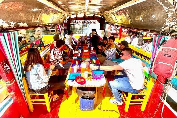 El interior de la trajinera, con el grupo alrededor de la mesa larga