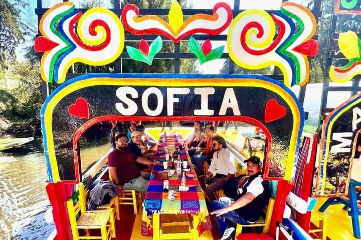 Grupo a bordo de la trajinera «Sofía», con la mesa puesta bajo el arco pintado