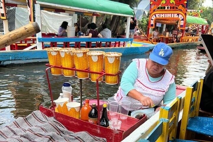 Una vendedora acerca su canoa con vasos escarchados